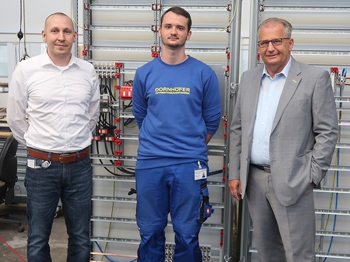 Tim Hütter (Mitte) lernt beim Automatisierungsspezialisten Dornhöfer den neuen Beruf des Elektronikers für Gebäudesystemintegration. Ausbildungskoordinator Christian Wurm (links) und Geschäftsführer Reimund Niederhöfer stehen ihm zur Seite. - © ZVEH
 Tim Hütter (Mitte) lernt beim Automatisierungsspezialisten Dornhöfer den neuen Beruf des Elektronikers für Gebäudesystemintegration. Ausbildungskoordinator Christian Wurm (links) und Geschäftsführer Reimund Niederhöfer stehen ihm zur Seite.