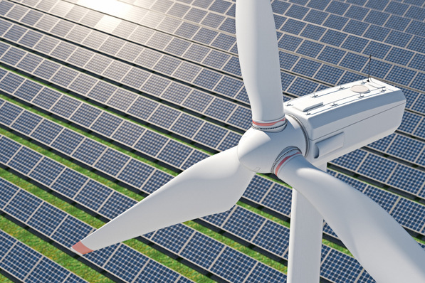 Luftaufnahme einer großen Windkraftanlage, die an einem sonnigen Tag über einem Feld aus Solarmodulen aufragt. - © Negro Elkha - stock.adobe.com