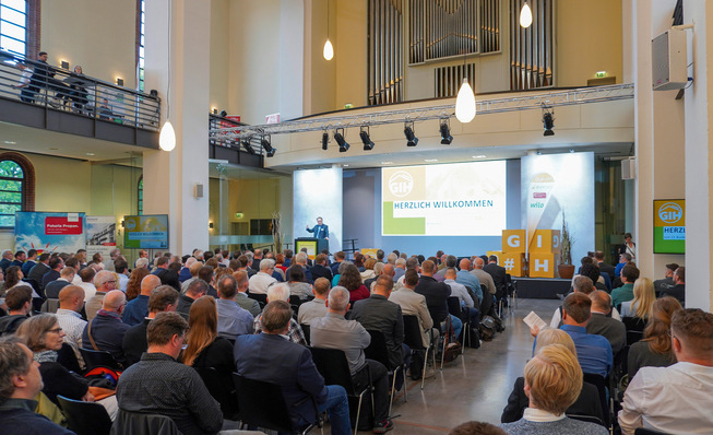 Ein großes Publikum hört einem Redner bei einer Konferenz in einem geräumigen, modernen Saal mit hohen Decken zu. - © Bild: GIH