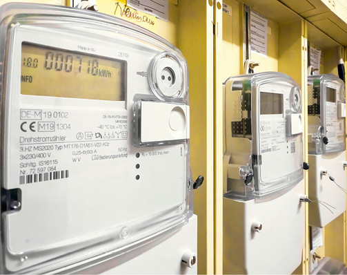 Nahaufnahme mehrerer digitaler Stromzähler, die auf einer gelben Tafel montiert sind. - © Bild: Robert Poorten - stock.adobe.com