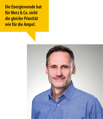 Mann mit kurzen Haaren und Bart im blauen Hemd, Zitat auf Deutsch über Energiepolitik und politische Prioritäten. - © Bild: privat